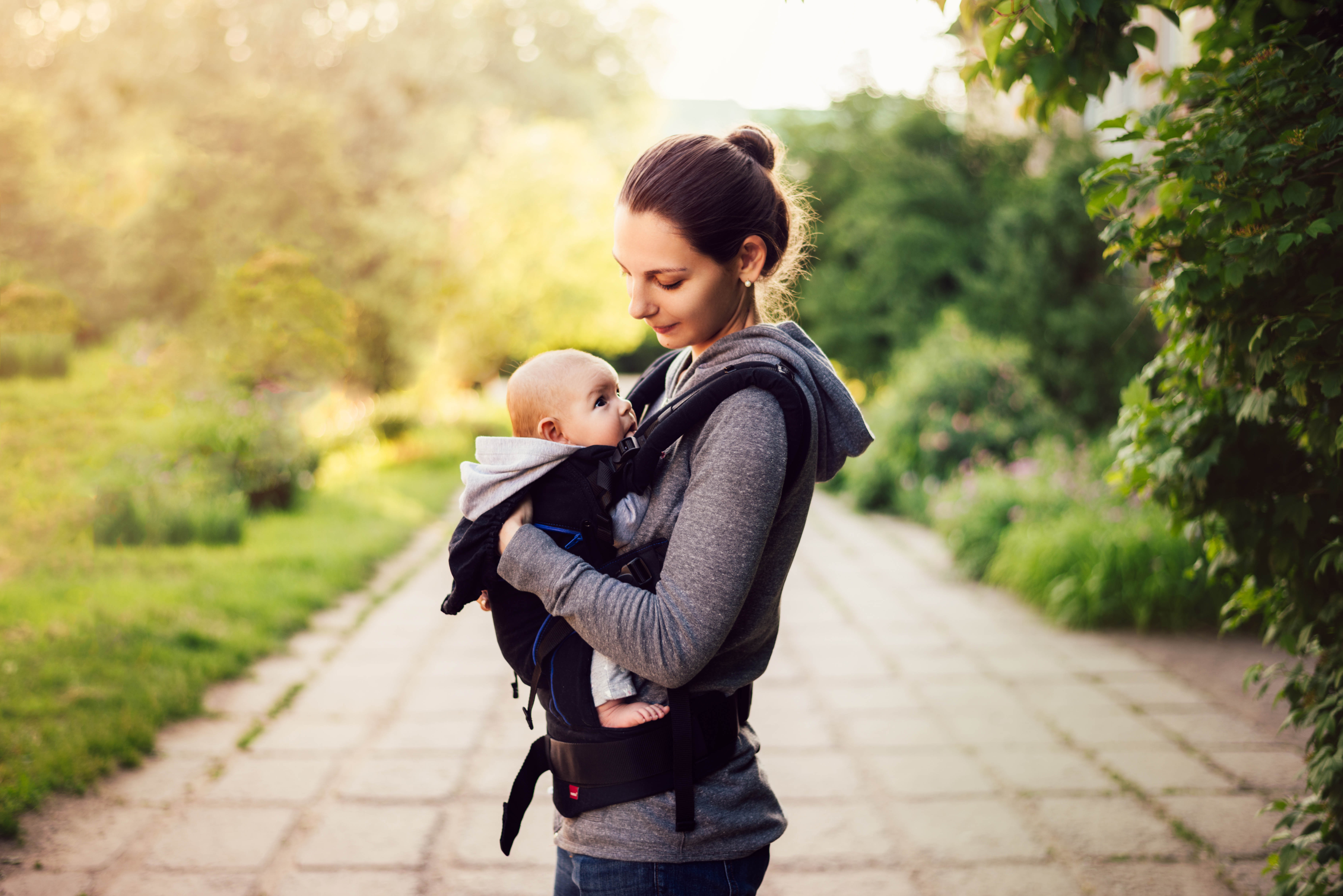 New, young mom baby-wearing and outside for a walk